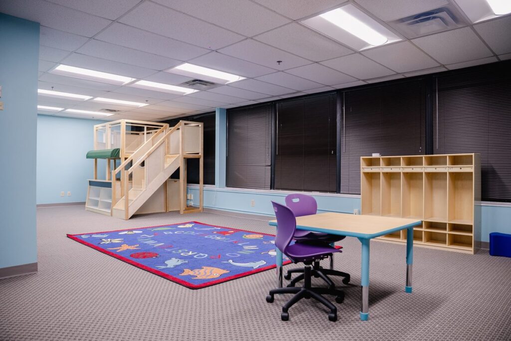 Open activity room with a play loft and cubbies at the Step It Up ABA Northlake center
