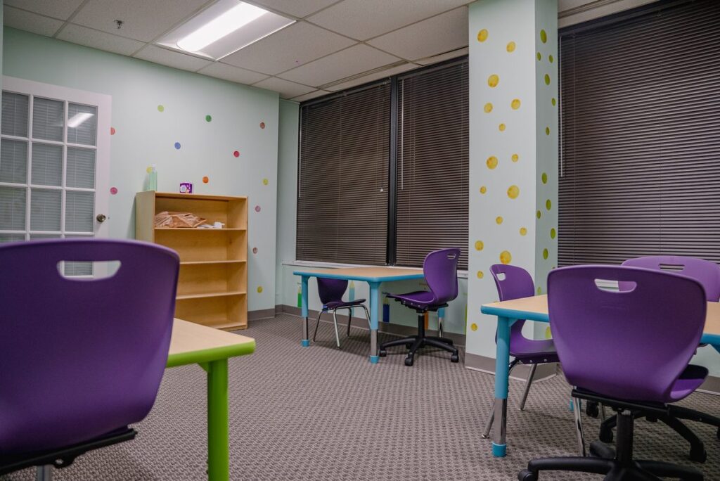 Classroom with tables, chairs and shelves at the Step It Up ABA Northlake center