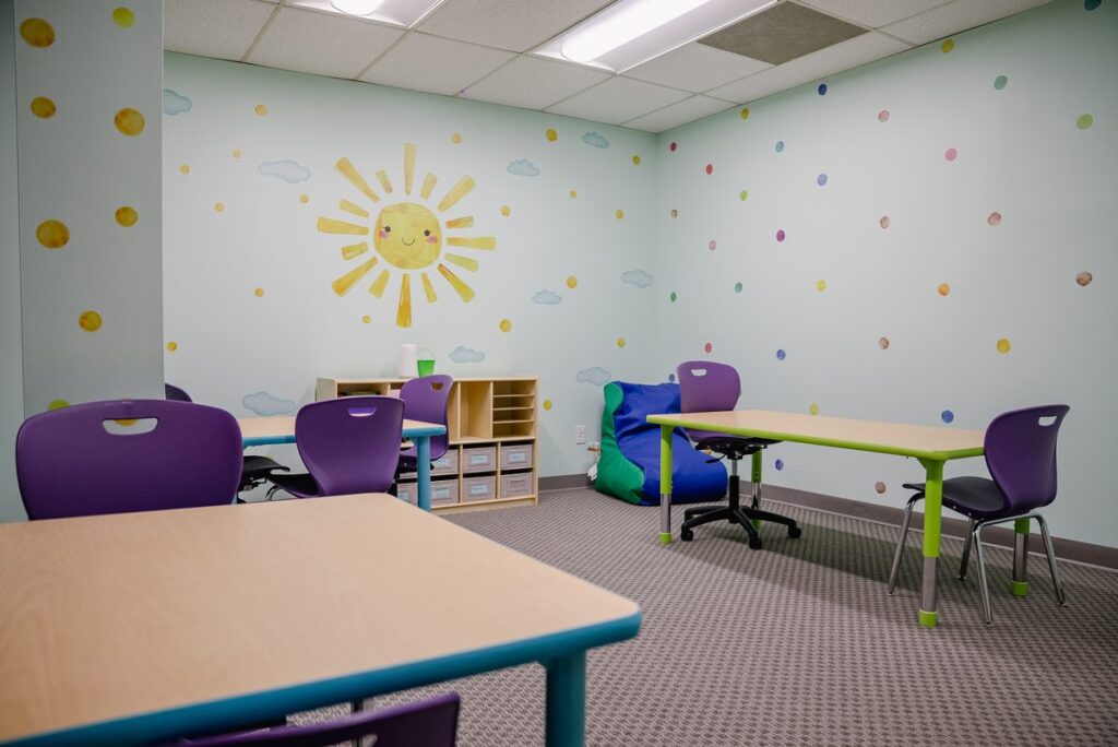 Learning room with purple chairs and tables at the Step It Up ABA Northlake center