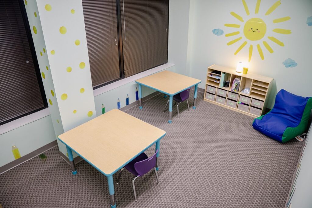 Bright room with a sun mural, bean bag and table at the Step It Up ABA Northlake center
