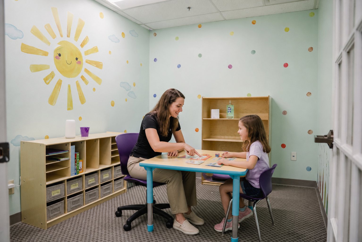 ABA therapist working one-on-one with a child at a table in the Step It Up ABA center